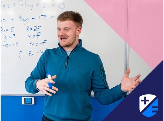 Teacher David Langley speaking in front of a whiteboard