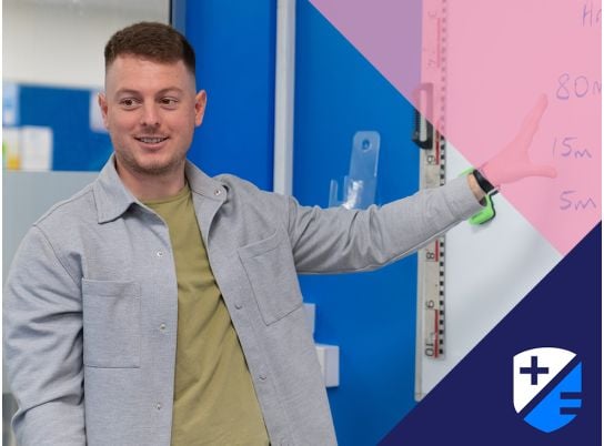 Teacher Seadhan speaking in front of a whiteboard