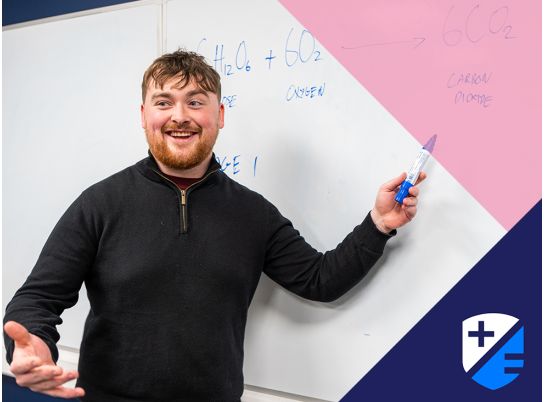 Teacher Alex Burke in front of a whiteboard 