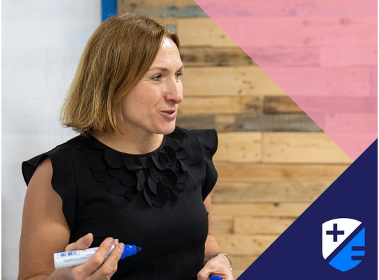 Teacher Dagmara Furman speaking in front of whiteboard