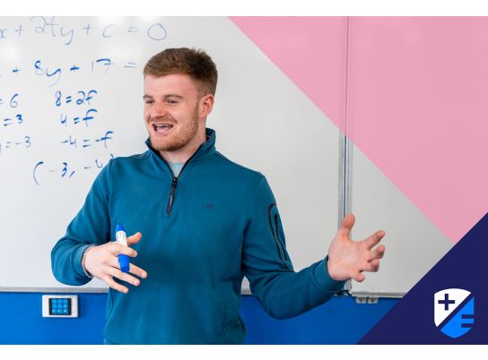 Teacher David Langley speaking in front of a whiteboard