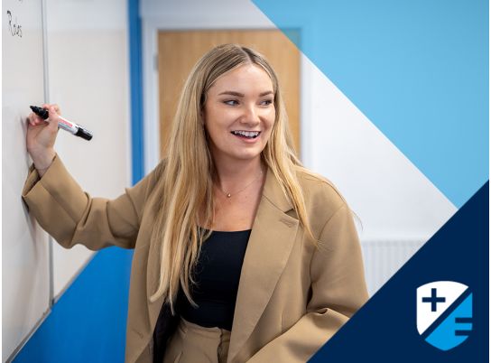Teacher Kate Fahey writing on whiteboard