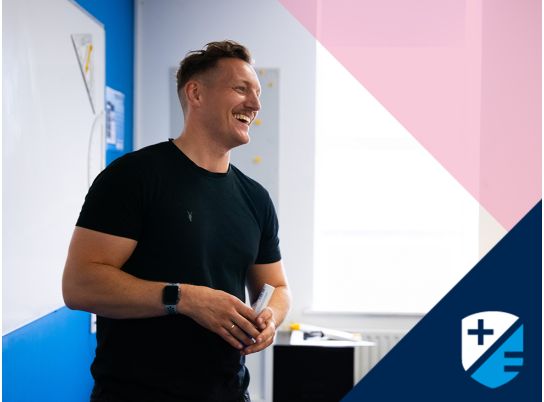 Teacher Gavin Cowzer speaking in front of a whiteboard