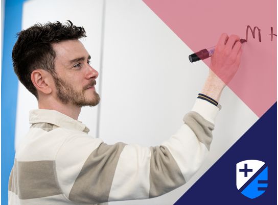 Teacher Kevin Fitzpatrick writing on a whiteboard