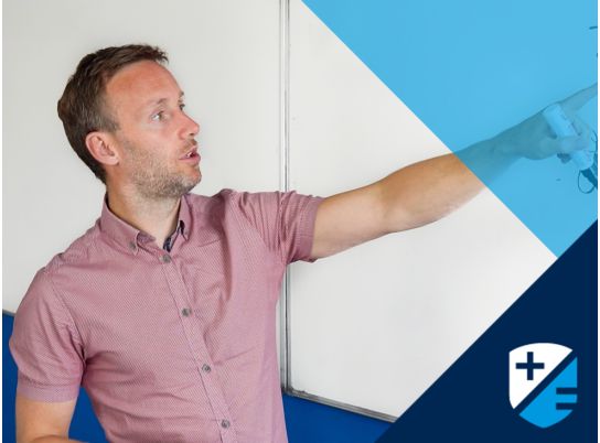 Teacher Carl Brien writing on whiteboard