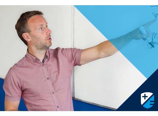 Teacher Carl Brien writing on whiteboard