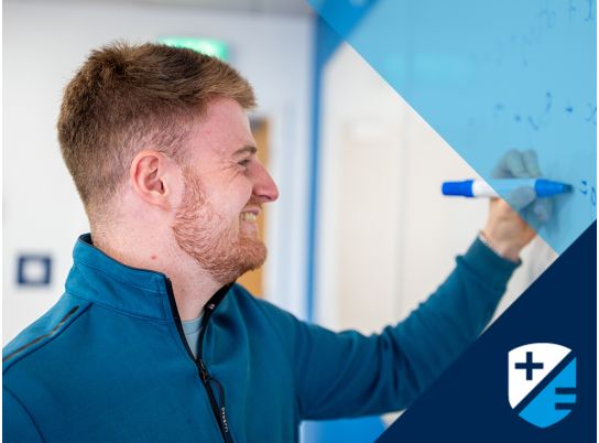 Teacher David Langley writing on whiteboard
