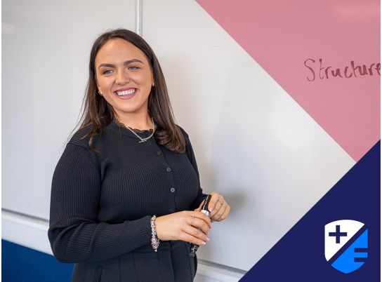 Teacher Megan Mulvihill speaking in front of a whiteboard