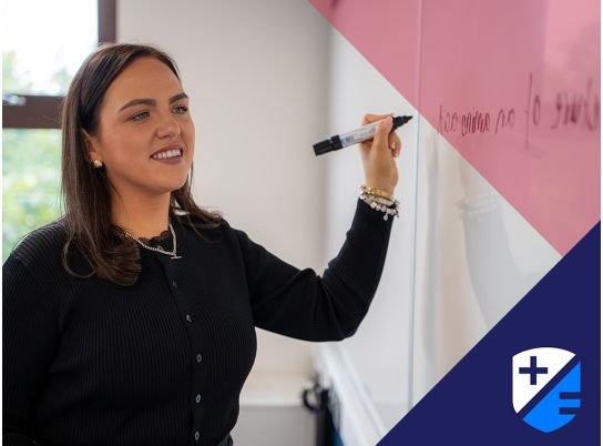 Teacher Megan Mulvihill writing on whiteboard