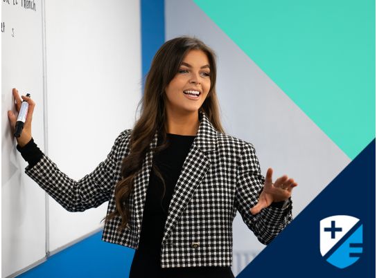 Teacher Katie Lenahan speaking in front of a whiteboard