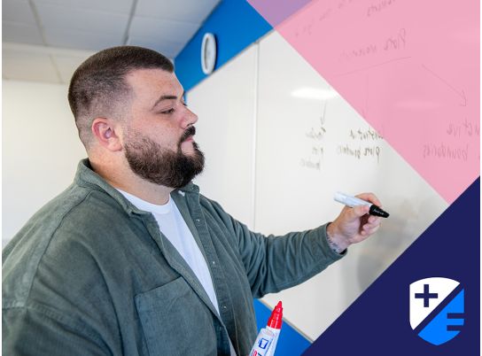 Teacher Thomas Maher writing on whiteboard