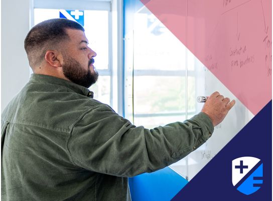 Teacher Thomas Maher writing on whiteboard