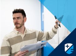 Teacher Kevin Fitzpatrick speaking in front of a whiteboard