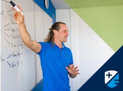Teacher Barry Drumm speaking in front of a whiteboard