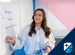 Teacher Caoimhe Ni Mhuircheartaigh speaking in front of a whiteboard