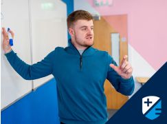 Teacher David Langley speaking in front of a whiteboard