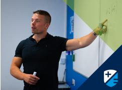 Teacher Dave Lewis pointing to a whiteboard