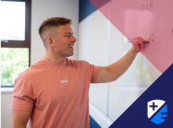 Teacher David Lewis writing on a whiteboard 