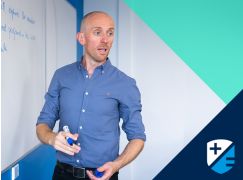 Teacher JP Sweetman speaking in front of a whiteboard