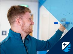 Teacher Dave Langley writing on a whiteboard
