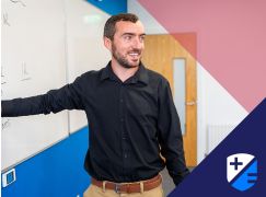 Teacher Patrick Lee speaking in front of a whiteboard