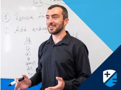 Teacher Patrick Lee speaking in front of whiteboard