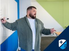 Teacher Thomas Maher speaking in front of a whiteboard